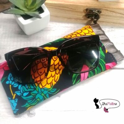 une paire de lunettes est posé sur un étui à lunettes à cliquet réalisé en tissu wax au motif ananas fleuri